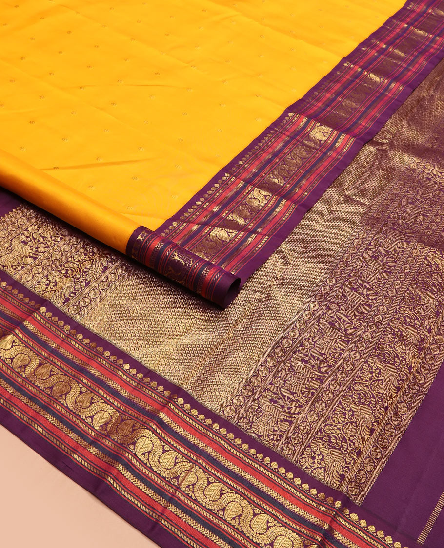Yellow zari buttas Kanchipuram silk saree, contrast border of thilakam mokku, banaras, kathir, and dhavana manga designs, and mayil kann design pallu