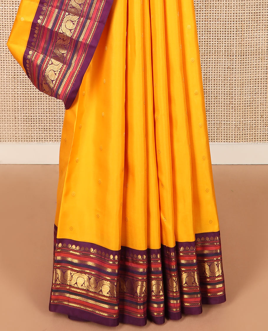 Yellow zari buttas Kanchipuram silk saree, contrast border of thilakam mokku, banaras, kathir, and dhavana manga designs, and mayil kann design pallu