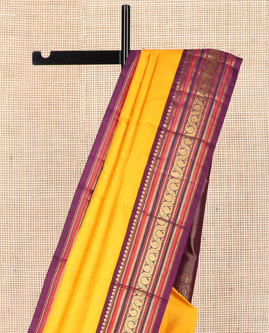 Yellow zari buttas Kanchipuram silk saree, contrast border of thilakam mokku, banaras, kathir, and dhavana manga designs, and mayil kann design pallu