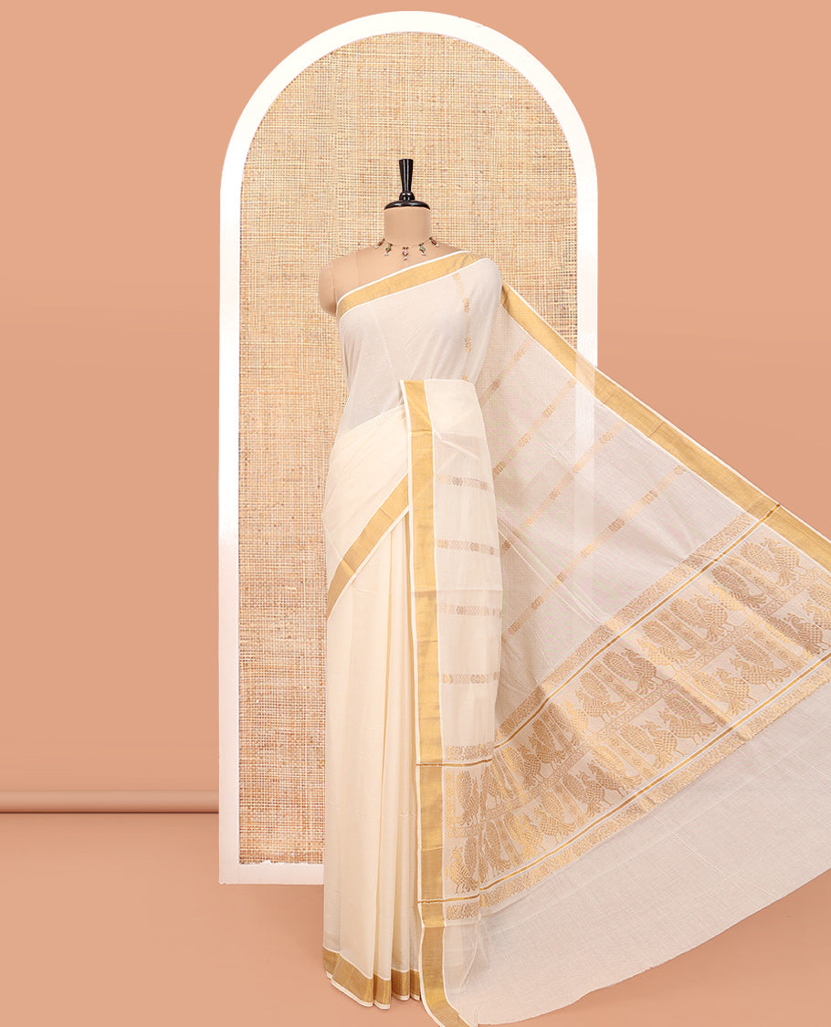 Cream Kerala Cotton Saree, Highlighted by Zari Stripes All Over Its Body, a Subtle Bavanji Border, Pallu Steeped with Peacock Designs, and Paired with a Matching Blouse