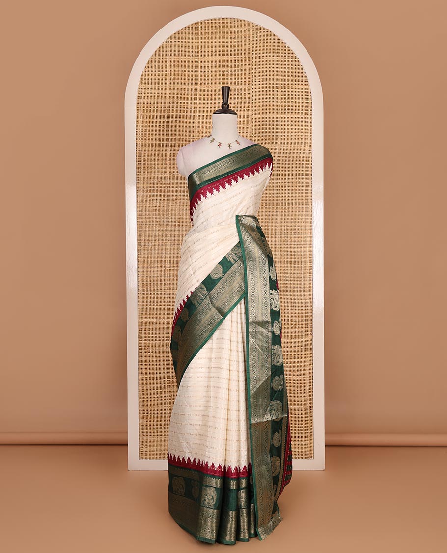 Half-white zari designs dola silk saree, contrast green temple traditional border of peacock and elephant motifs, and temple pallu
