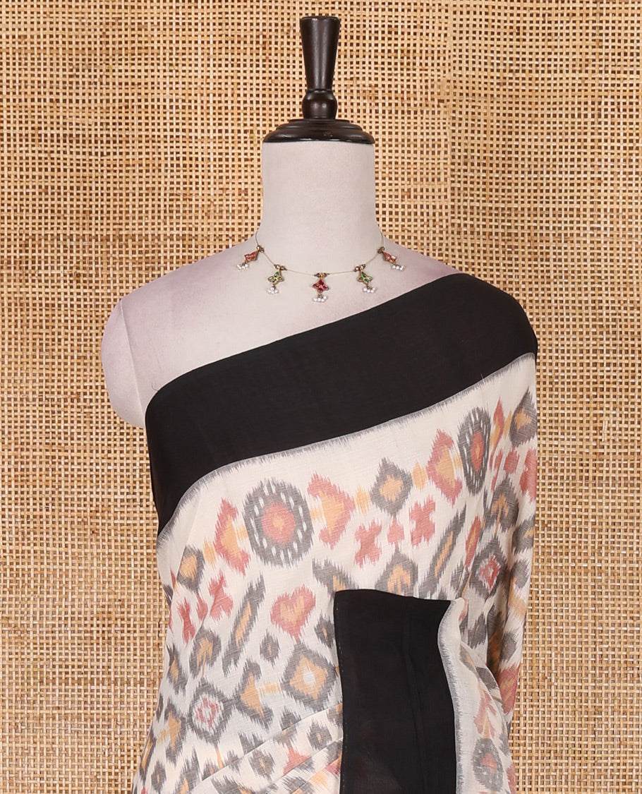 Half white intricate motifs featured ikkat cotton saree, contrast plain border, ikkat design pallu, and contrast plain blouse