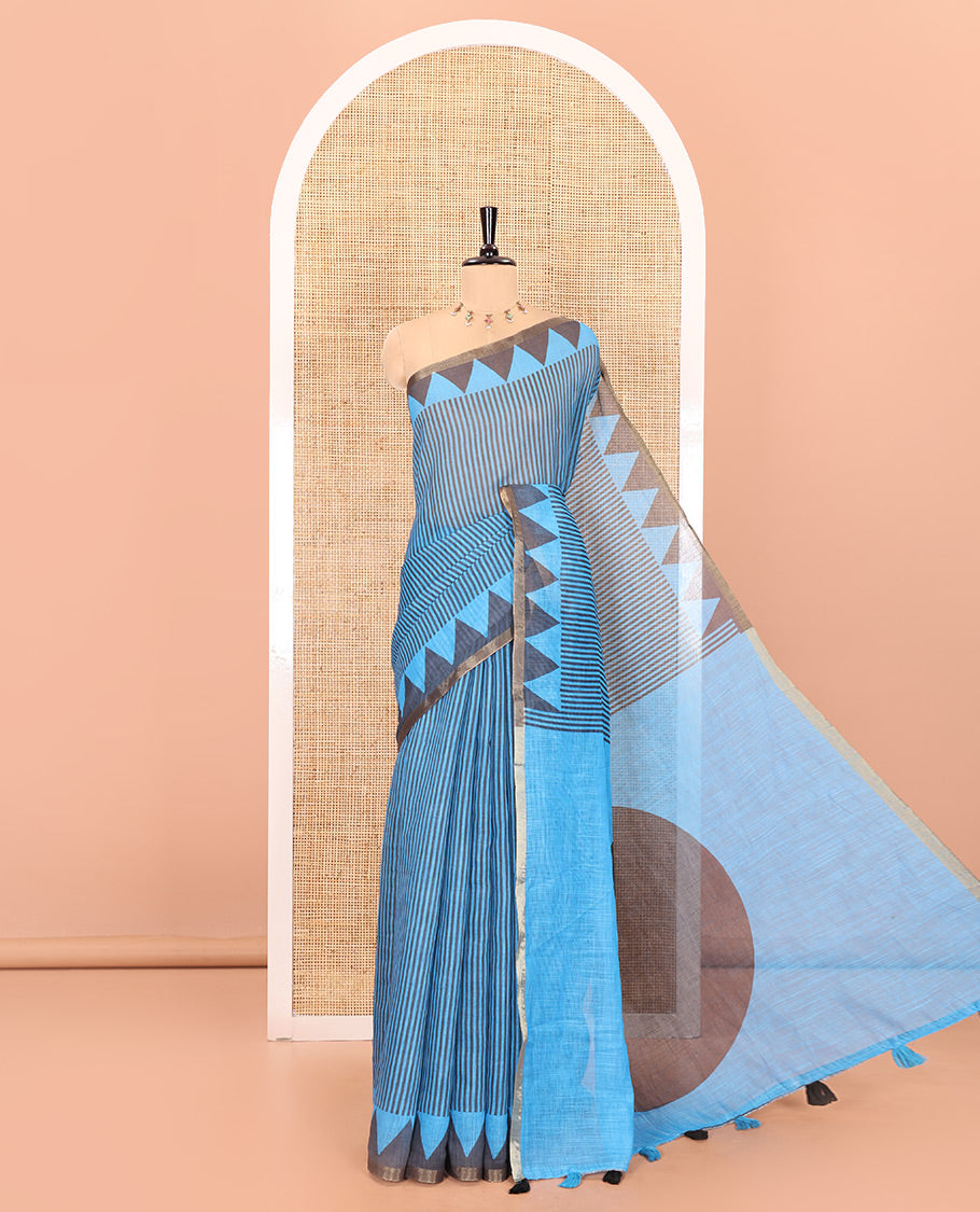 Blue vertical stripes printed linen cotton saree, a temple-printed border, big polka dot printed pallu, and a printed blouse