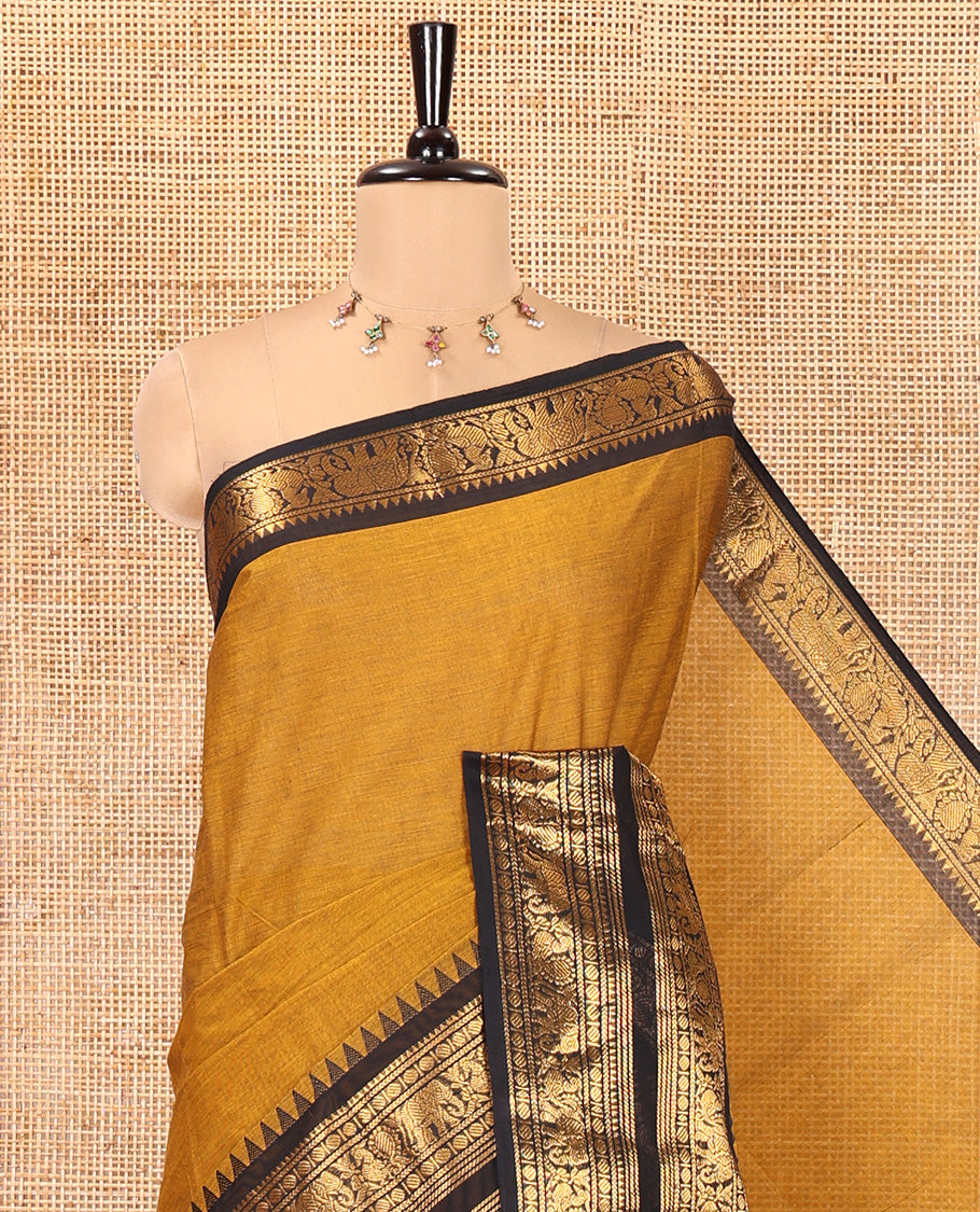 Mustard Plain Chettinad Cotton Saree, Complemented by a Contrast Rettai Pettu Zari Border of Thread-Temple, Coin, Elephant, and Peacock Designs, Subtly Striped Pallu, and Paired with a Matching Blouse