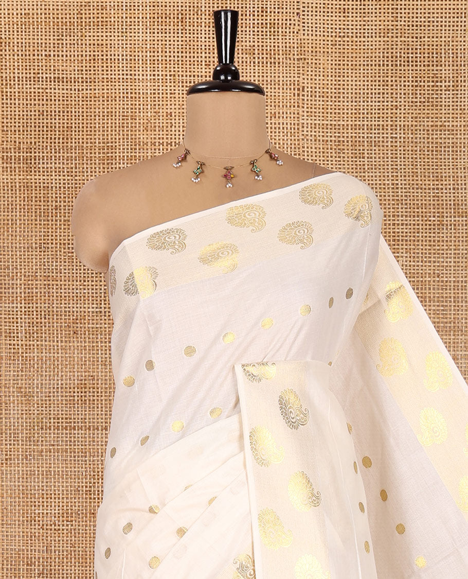 Cream Kerala Cotton Saree, Spotlighted with Zari Buttas, Highlighted by Zari Border, Intricate Pallu, and a Matching Blouse