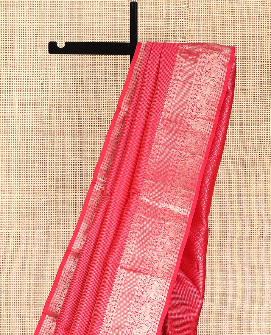 Red Vasundhara Silk Saree, Subtly Sparkled with Zari Checks All Over Its Body, Highlighted by Zari Border of Thilakam Mokku, Kamalam, Mayil Kann, Rudraksham, and Kuthirai Designs, Pallu of Jaal Designs, and Paired with a Matching Blouse