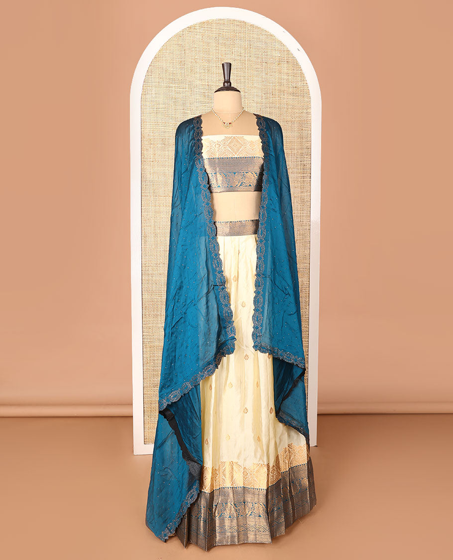 Cream-blue art-silk half-saree, zari buttas with contrast traditional design bordered skirt, a matching blouse, and scallop stone work dhavani