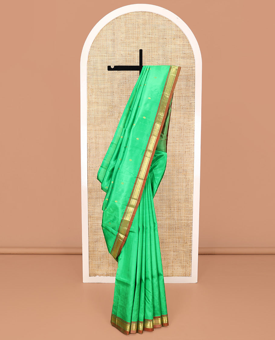 Green Kanchipuram Silk Saree, Embellished with Zari Buttas All Over Its Body, Complemented by a Contrast One-Sided Border of Banaras, and Jaal Designs, Pallu of Zari Designs, and Comes Without a Blouse