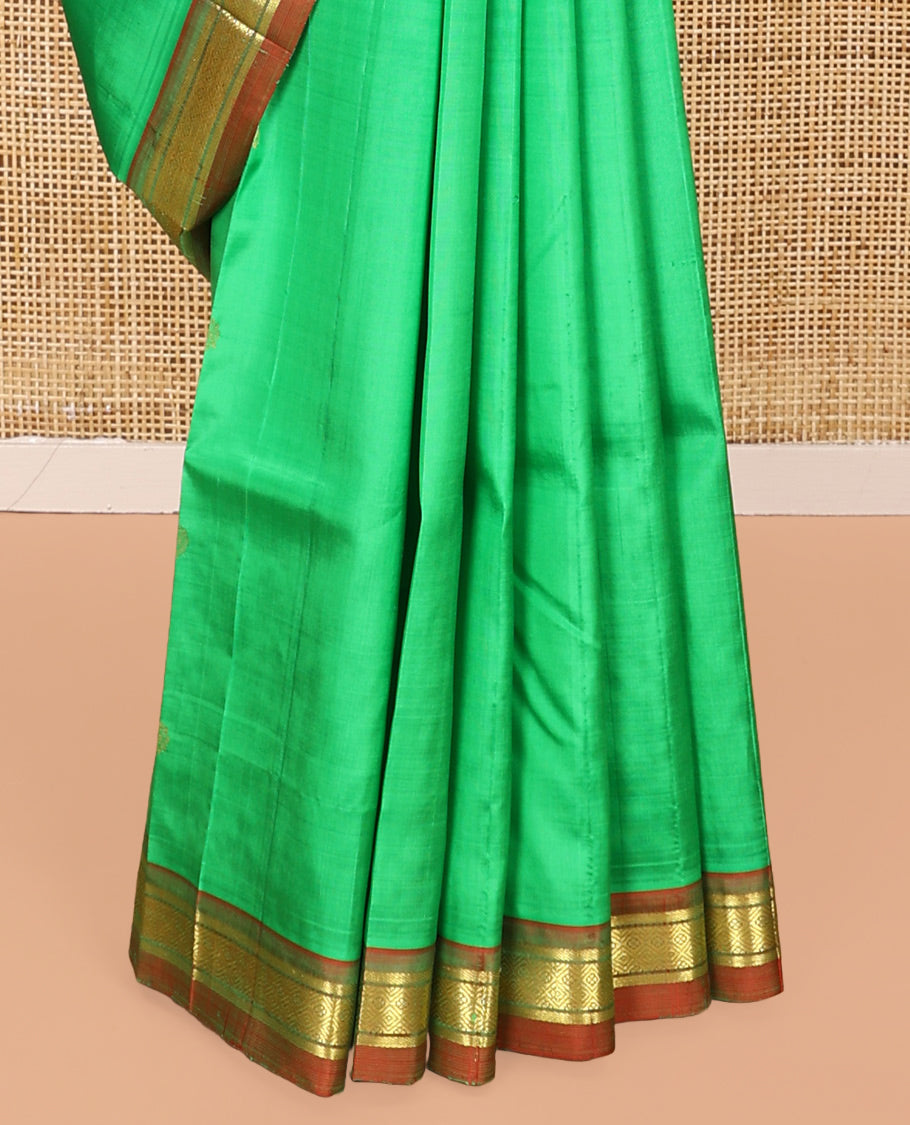 Green Kanchipuram Silk Saree, Embellished with Zari Buttas All Over Its Body, Complemented by a Contrast One-Sided Border of Banaras, and Jaal Designs, Pallu of Zari Designs, and Comes Without a Blouse