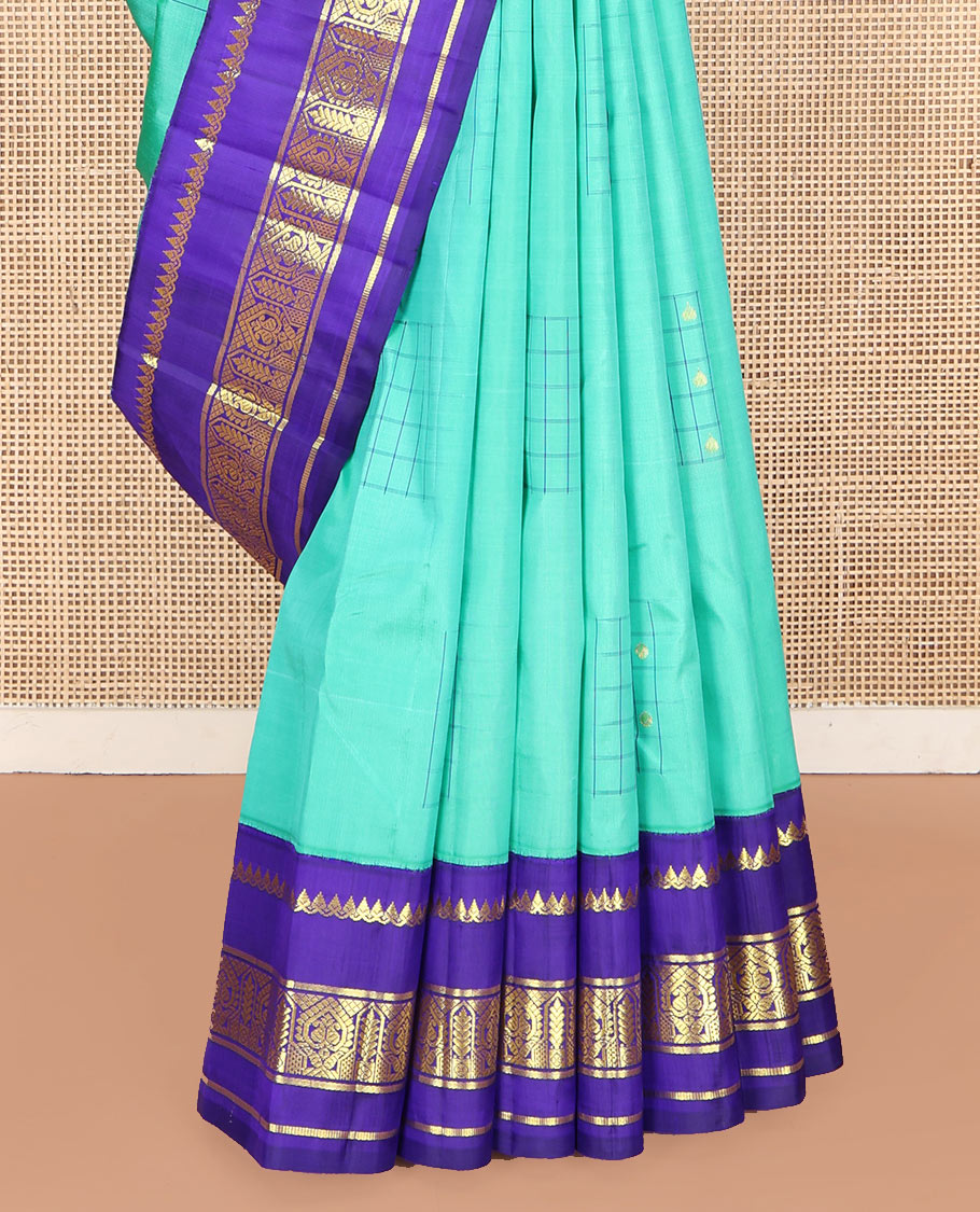 Turquoise Kanchipuram Silk Saree, Subtly Sparkled with Checked Buttas on Its Body, Complemented by a Contrast One-Sided Korvai Border of Thilakam Mokku, and Manga Designs, Pallu of Peacock Chariot Designs, and Comes Without a Blouse