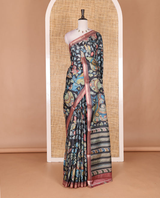 Black-base multi-color kalamkari floral-vine and peacocks printed semi-tussar saree, gold zari piping border, kalamkari printed pallu, and contrast printed blouse