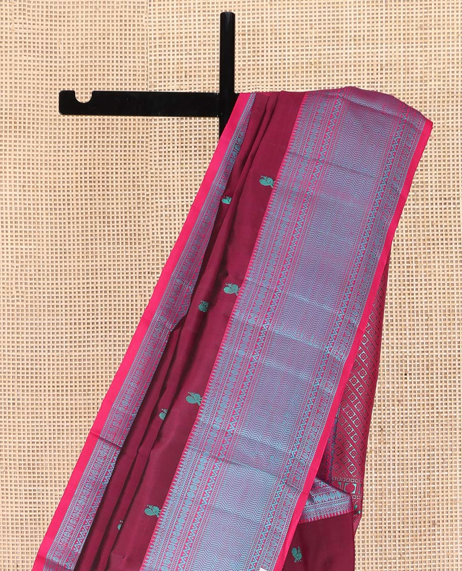 Wine Kanchipuram Silk Saree, Adorned with Mayil-Chakram Buttas All Over Its Body, Complemented by a Contrast Border of Thilakam, Banaras, Muthu, Rudraksham, Neli, and Vanki Designs, and Pallu Steeped with Kamalam Designs, and Paired with a Contrast Blouse