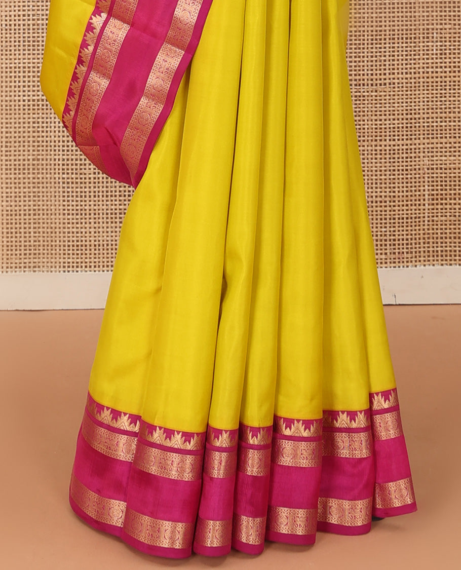 Lemon yellow plain Kanchipuram silk saree, contrast rettai pettu border of thazampoo rekku, neli, poo chakram, and kuthirai designs, and jaal pallu