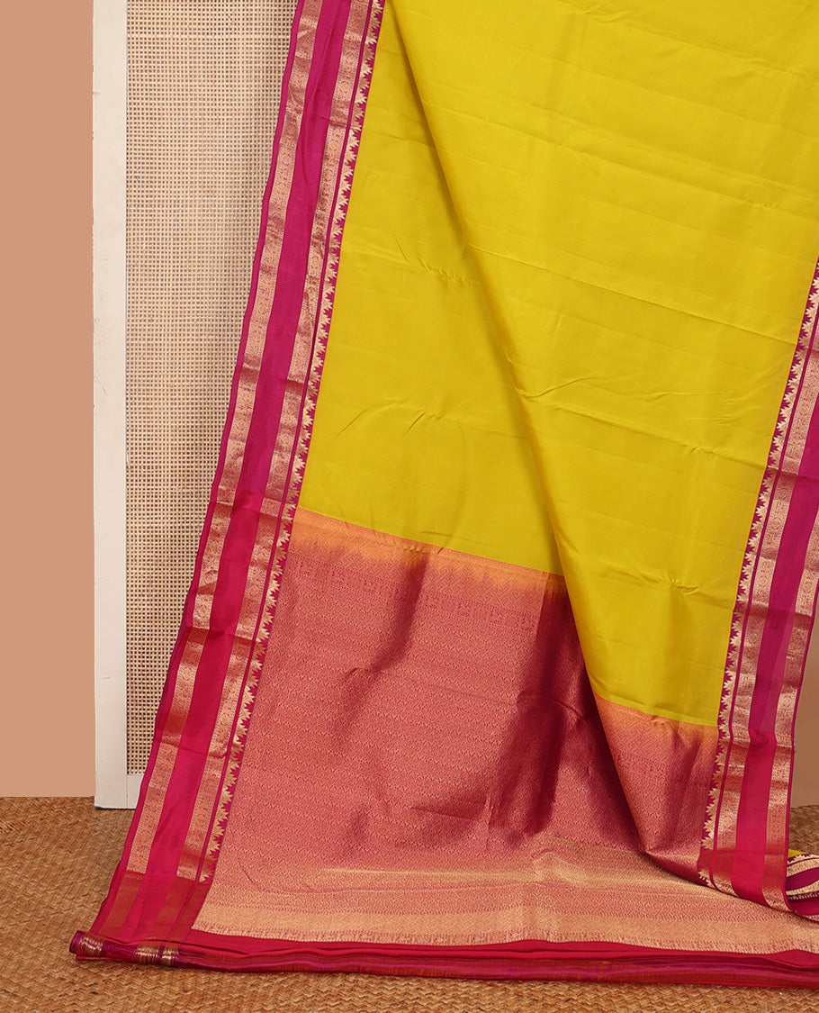 Lemon yellow plain Kanchipuram silk saree, contrast rettai pettu border of thazampoo rekku, neli, poo chakram, and kuthirai designs, and jaal pallu