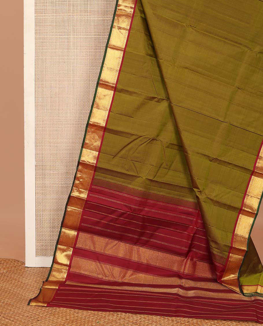 Green plain Kanchipuram silk saree, contrast border of thilakam mokku, muthu, cross kamalam, and zari stripes, and zari woven pallu