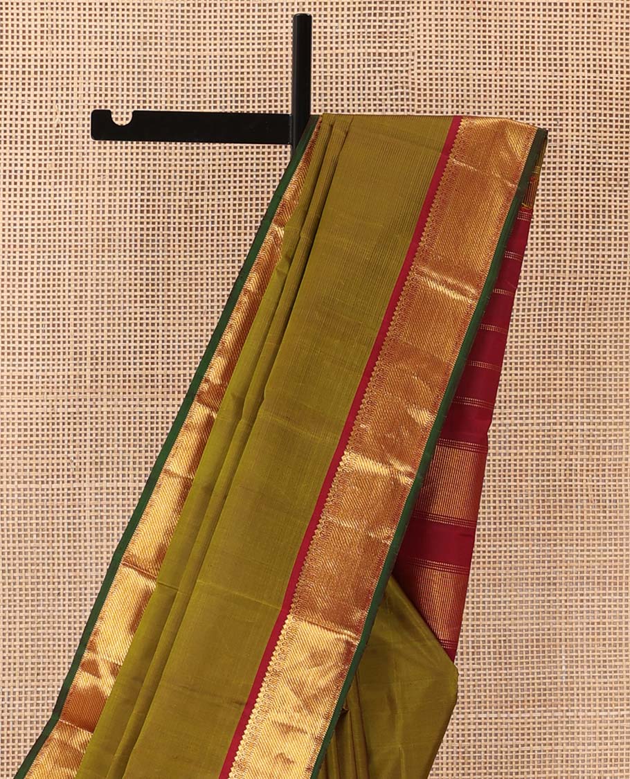 Green plain Kanchipuram silk saree, contrast border of thilakam mokku, muthu, cross kamalam, and zari stripes, and zari woven pallu