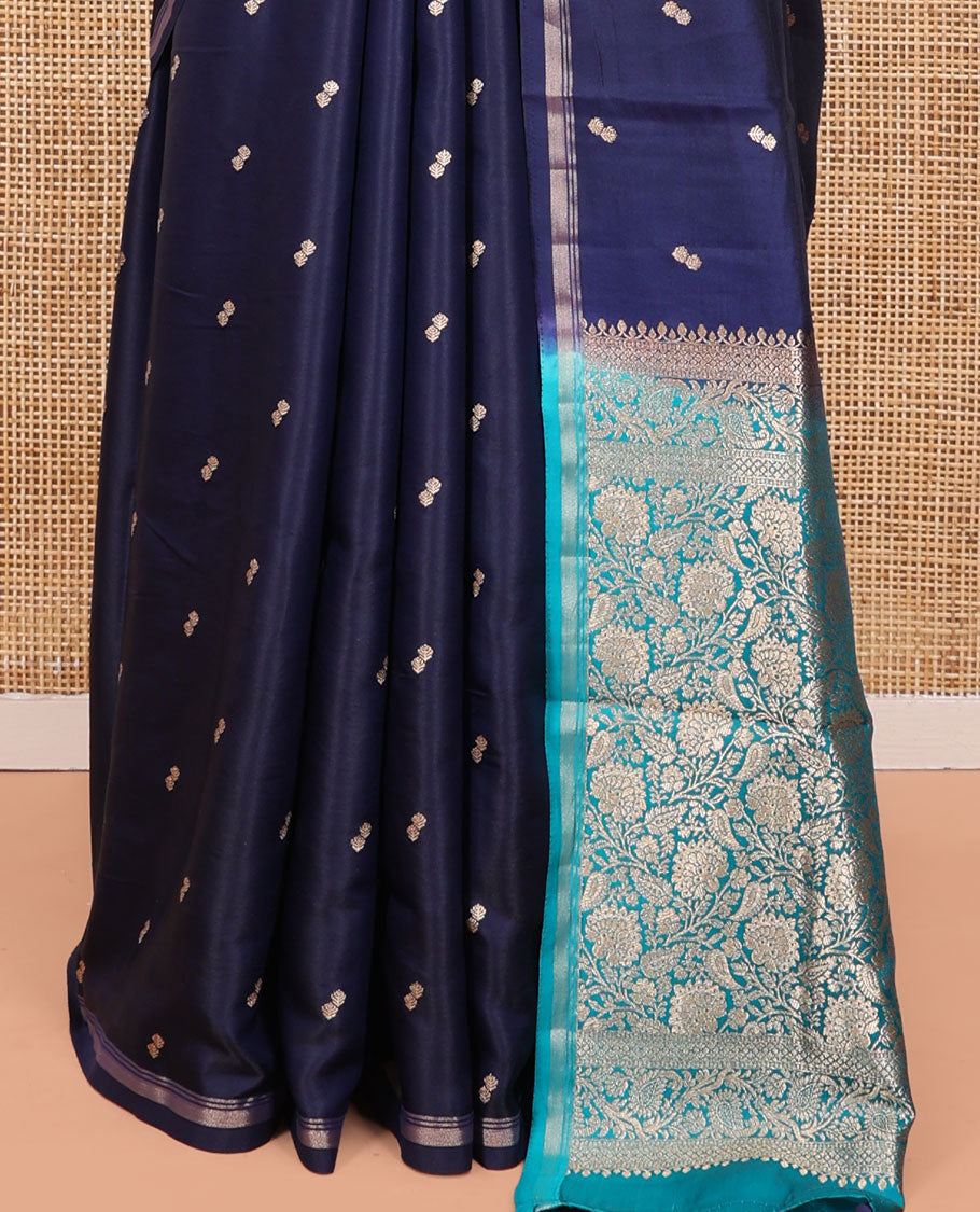 Navy Blue Satin Silk Saree, Delicately Woven with Buttas All Over Its Body, a Subtle Piping Border, Complemented by a Contrast Pallu of Floral-Paisley Designs in Zari, and Paired with a Contrast Blouse