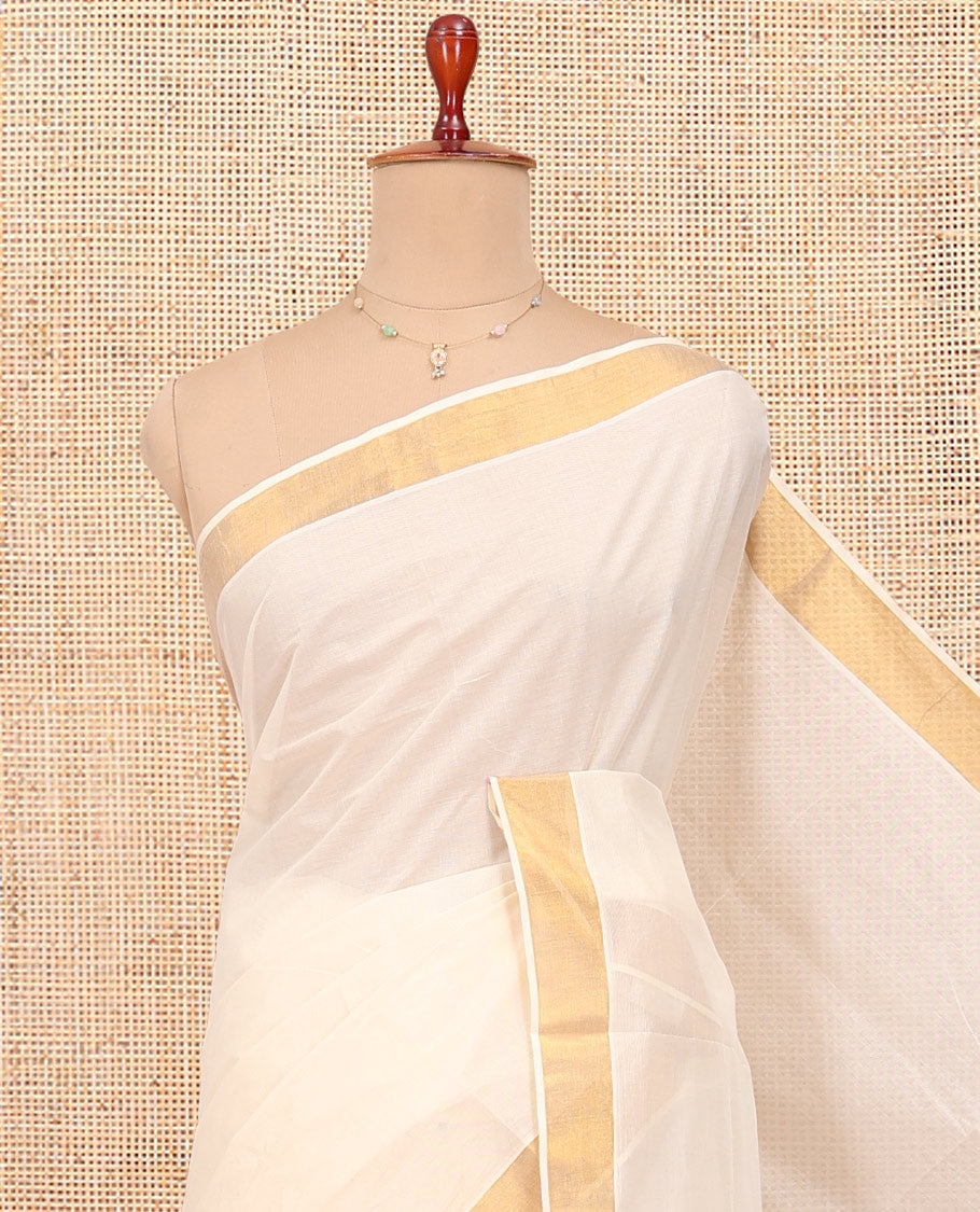 Cream Kerala Cotton Saree, Ornamented with Zari Buttas All Over Its Body, a Zari Bavanji Border, Pallu of Intricate Designs, and Paired with a Matching Blouse