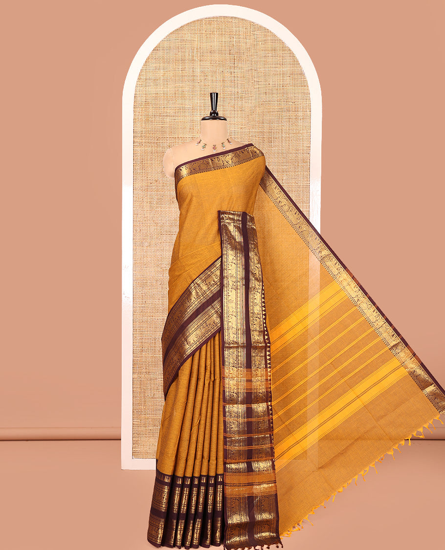 Mustard Plain Chettinad Cotton Saree, Complemented by a Contrast Rettai Pettu Zari Maroon Border of Temple, Coin, Elephant, and Peacock Designs, Subtly Striped Pallu, and Paired with a Matching Blouse
