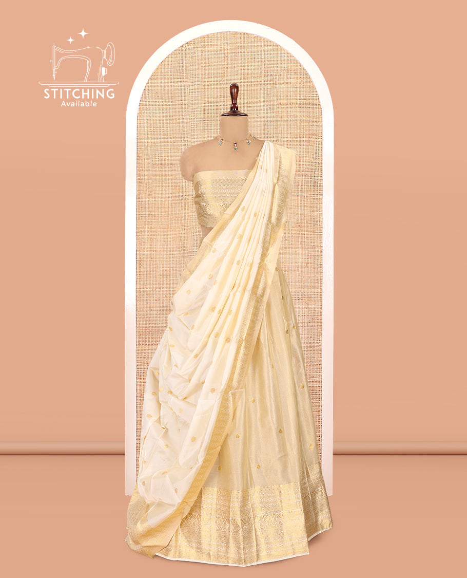 Cream Gold Tissue Half-Saree, Zari Buttas on Its Skirt, a Matching Blouse, an Intricately Zari-Designed Dhavani