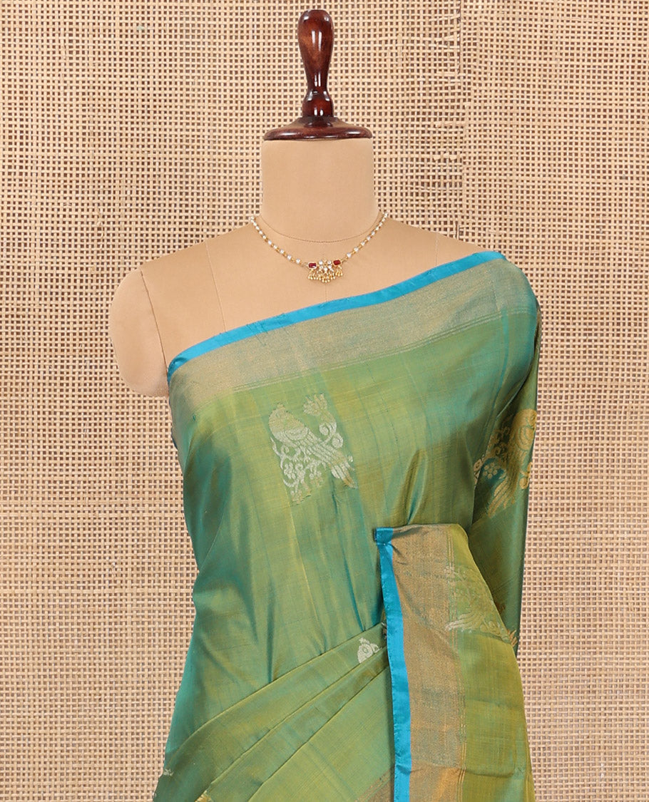Green Uppada Silk Saree Beautified with Parrot Buttas All Over Its Body, Complemented by Bavanji Border, Captivating Pallu Depicting the Same Parrot Motifs, and Paired with a Contrast Blouse