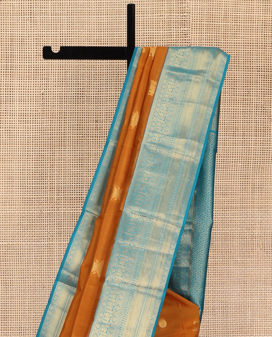 Orange Vasundhara Lite Silk Mix Saree, Detailed with Mayil, Chakra, and Iruthalai Pakshi Buttas, Complemented by Contrast Border of Thilakam Mokku, Mayil, Manga, Vanki, and Mayil Kann Designs, Opulently Embellished Jaal Pallu, and a Contrast Blouse