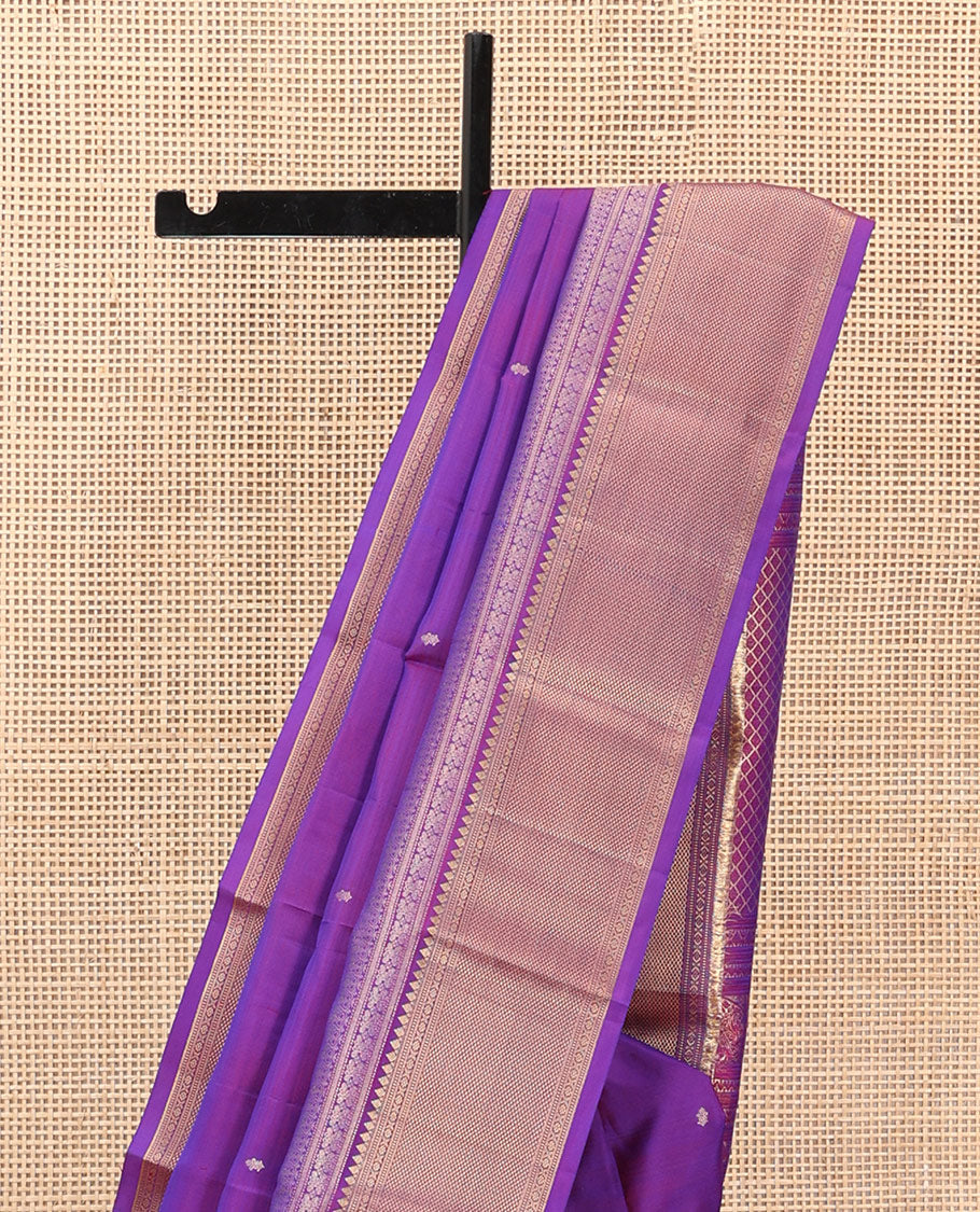 Violet Vasundhara Silk Saree Gracefully Embellished with Zari Buttas, Highlighted by a Zari Border Featuring Thilakam Mokku, Muthu, Cross Kamalam, and Mayil Kann Designs, Elegantly Embellished Pallu, and Paired with a Matching Blouse
