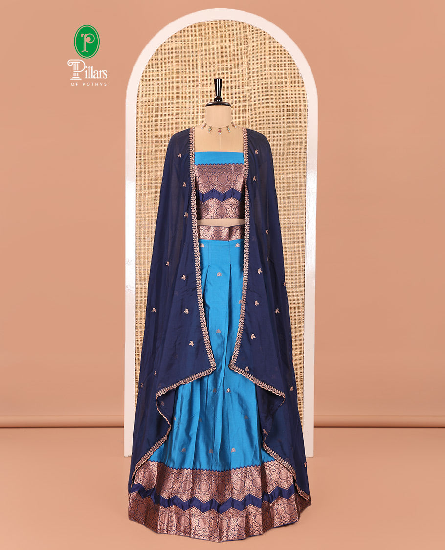 Light Blue and Navy Blue Semi-Banarasi Half-Saree Adorned with Zari Buttas on Its Skirt, Complemented by Contrast Traditional Zari Border of Chakram Designs, Paired with a Matching Blouse, and a Satin Georgette Embroidered Scallop Dhavani