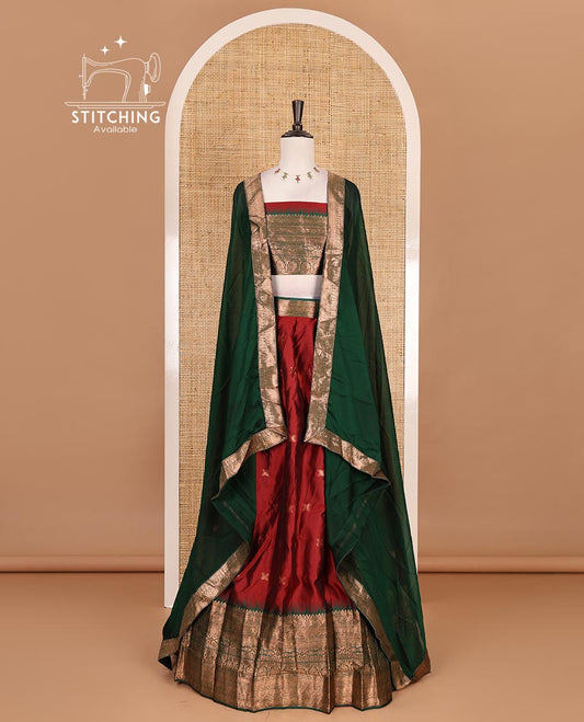 Maroon taffeta silk half saree, zari buttas with contrast green traditional zari border, matching zari blouse, and contrast plain zari border dhavani