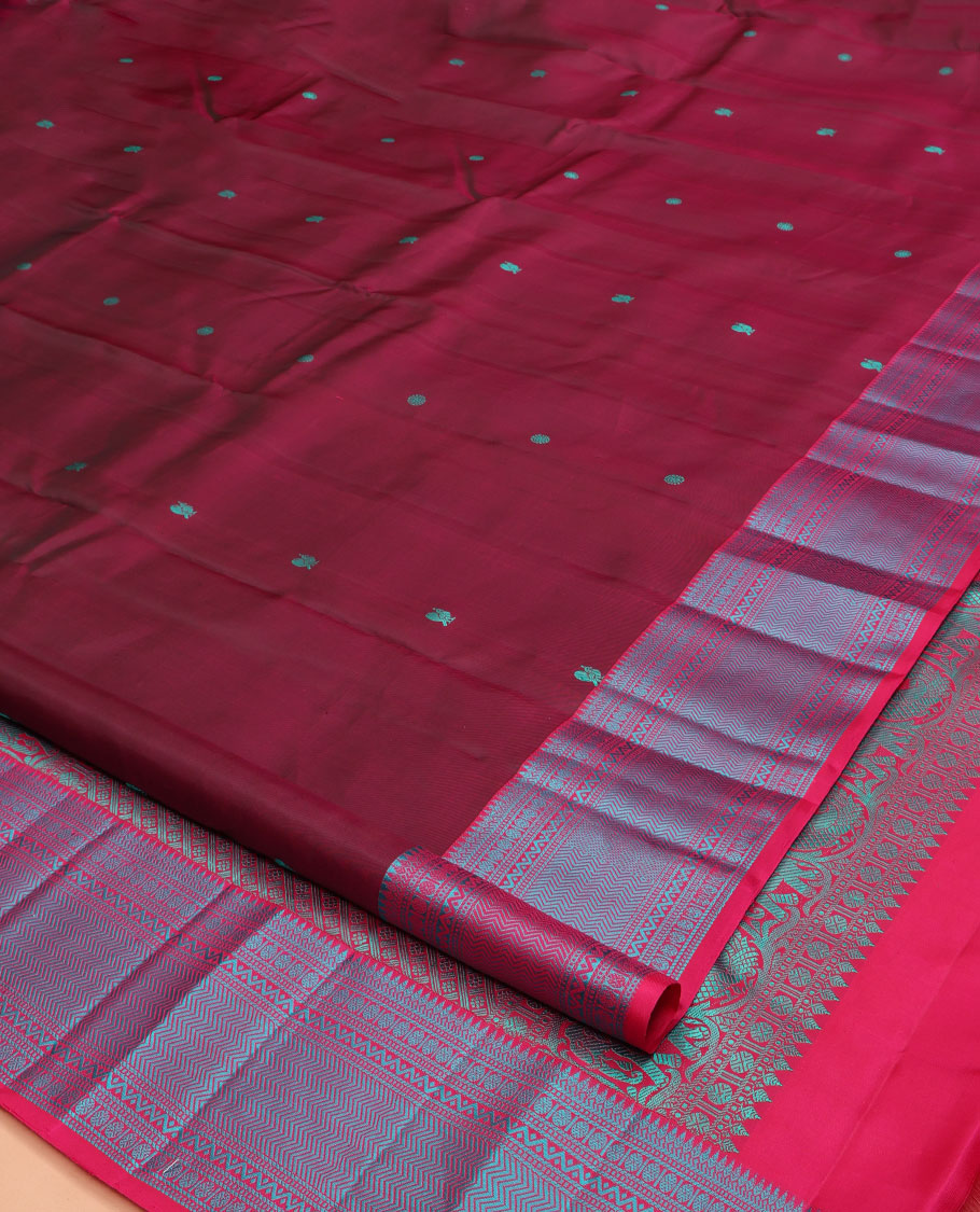 Wine Kanchipuram Silk Saree, Adorned with Mayil-Chakram Buttas All Over Its Body, Complemented by a Contrast Border of Thilakam, Banaras, Muthu, Rudraksham, Neli, and Vanki Designs, and Pallu Steeped with Kamalam Designs, and Paired with a Contrast Blouse