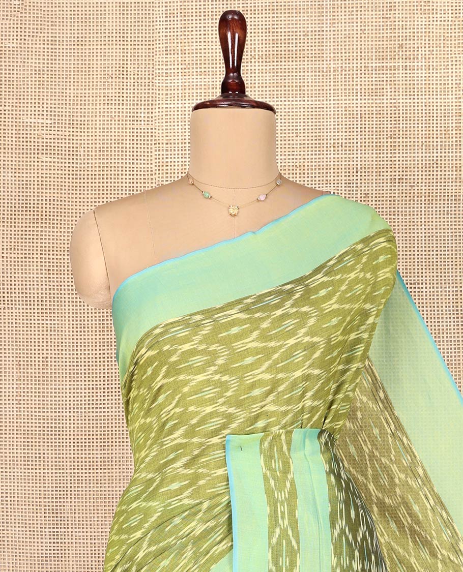 Light Green Ikkat Cotton Saree, Accentuated with Ikkat-Style Ogee Patterns on Its Body, Complemented by a Contrast Ikkat Textured Border, Pallu Steeped with Ikkat-Style Buttas, and Has No Blouse