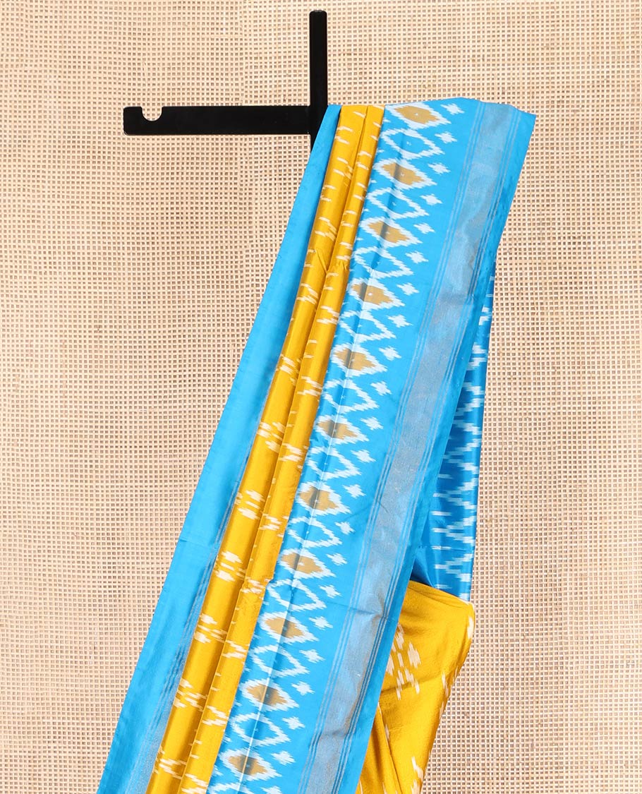 Mustard Ikkat Silk Saree, Masterfully Woven with Ikkat Buttas All Over Its Body, Complemented by a Contrast Diamond-Patterned Border, Pallu of Ikkat Butta Enclosed Checks, and Paired with a Contrast Blouse