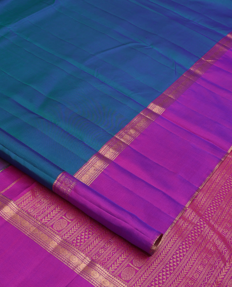 Blue plain Kanchipuram silk saree, contrast ganga jamuna rettai pettu border of rekku, neli, banaras, and rudraksham designs, and pallu of kathir, rudraksham, neli, poun, ara bogudi, and ara maadam