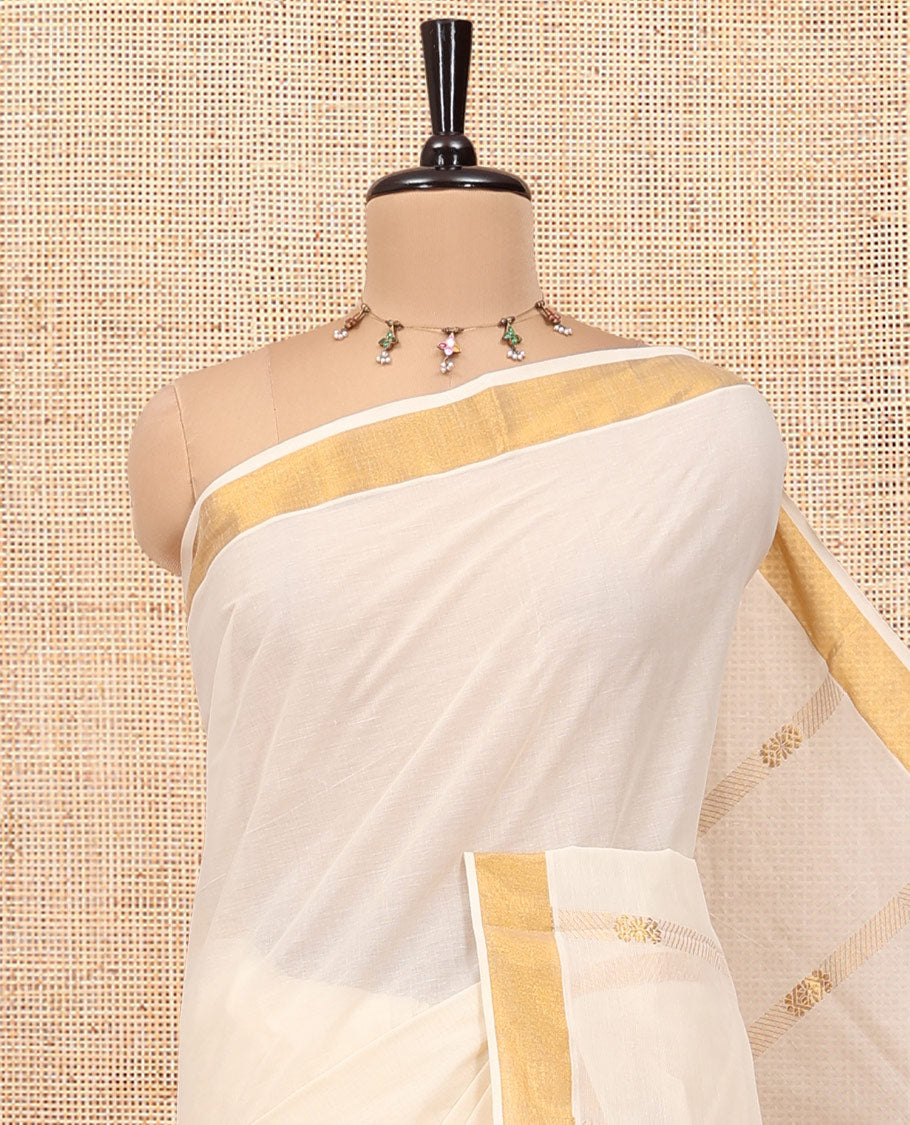 Cream Kerala Cotton Saree, Delicately Woven with Zari Stripes All Over Its Body, a Subtle Bavanji Border, Pallu Depicts Peacock Designs, and Paired with a Matching Blouse