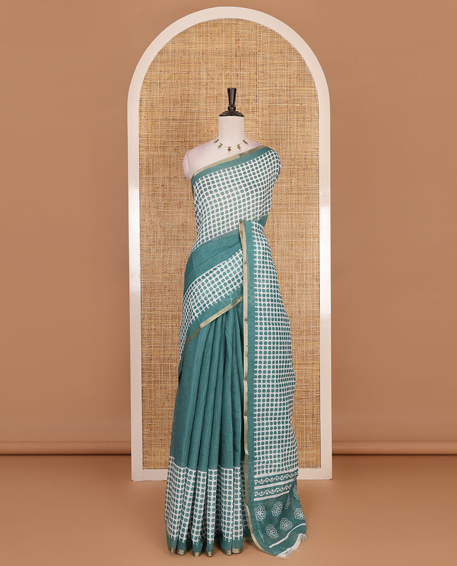 Green plain and polka dots printed linen cotton saree with piping zari border, floral-geometric print pallu, and contrast flower buttas printed blouse