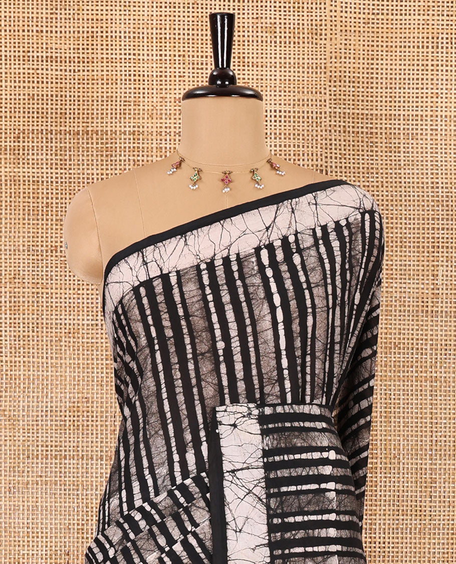 Black batik vertical stripes printed mul cotton saree, batik printed border, pallu of multi-color circle design, and a contrast batik printed blouse