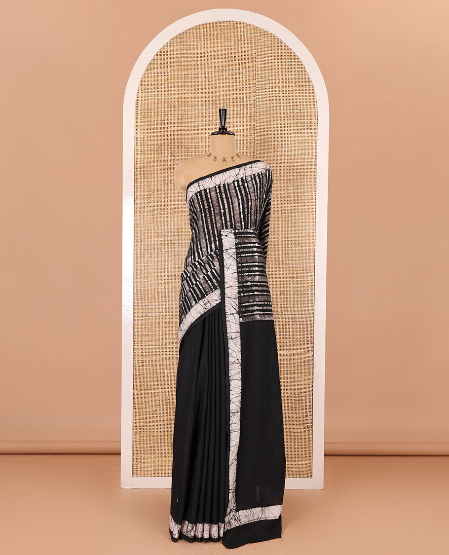 Black batik vertical stripes printed mul cotton saree, batik printed border, pallu of multi-color circle design, and a contrast batik printed blouse