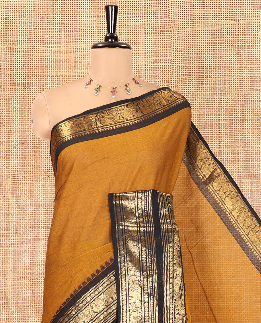 Mustard Plain Chettinad Cotton Saree, Complemented by a Contrast Rettai Pettu Dual-Color Zari Border of Temple, Coin, Elephant, and Peacock Designs, Subtly Striped Pallu, and Paired with a Matching Blouse