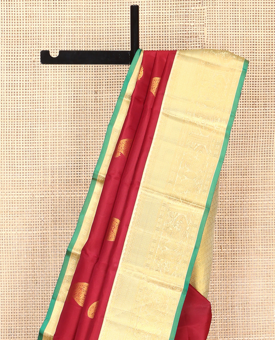 Maroon Vasundhara Silk Saree, Adorned with Arumbu Manga Buttas All Over Its Body, Complemented by Contrast Border of Thilakam Mokku, Mayil and Mayil Kann Designs, Grand Pallu and Paired with a Contrast Blouse