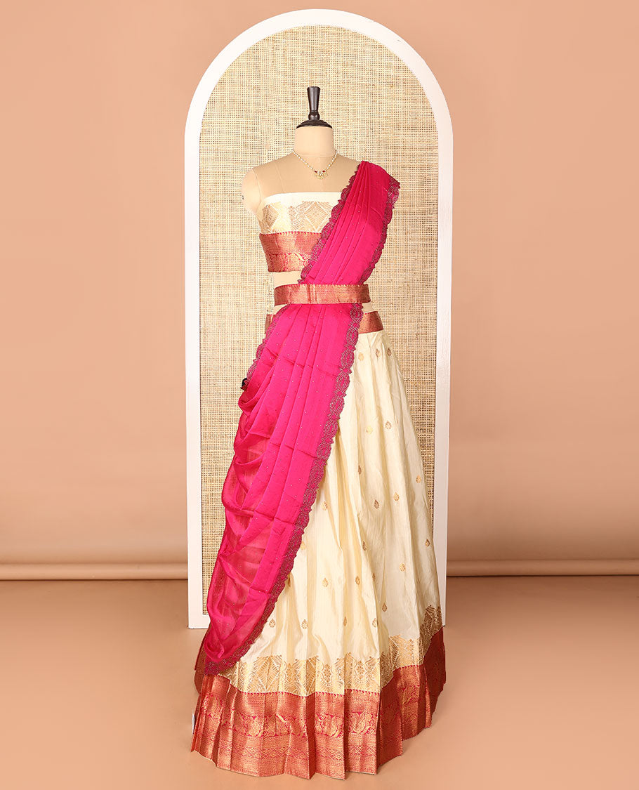 Cream-pink art-silk half-saree, zari buttas with contrast traditional design bordered skirt, a matching blouse, and scallop stone work dhavani