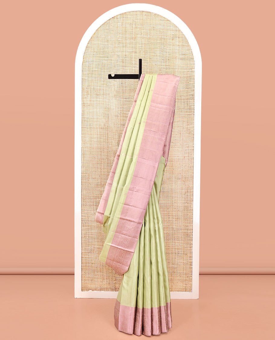 Pale Green Kanchipuram Designer Silk Saree, Subtly Sparkled With Buttas All Over Its Body Complemented by Contrast Traditional Designs Threaded Border, Subtly Woven Pallu, and Paired with a Contrast Blouse