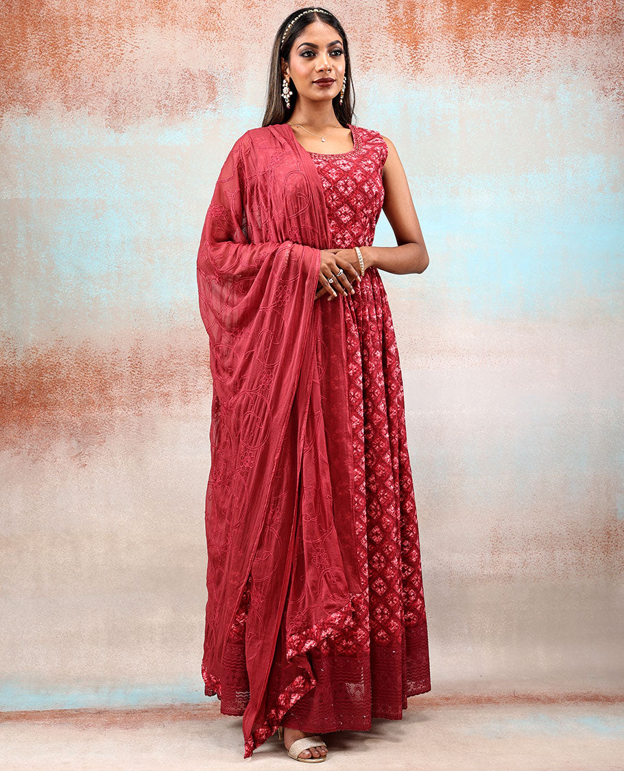 Red printed georgette Anarkali features intricate motifs, mirror work neck & thread embroidered border & dupatta
