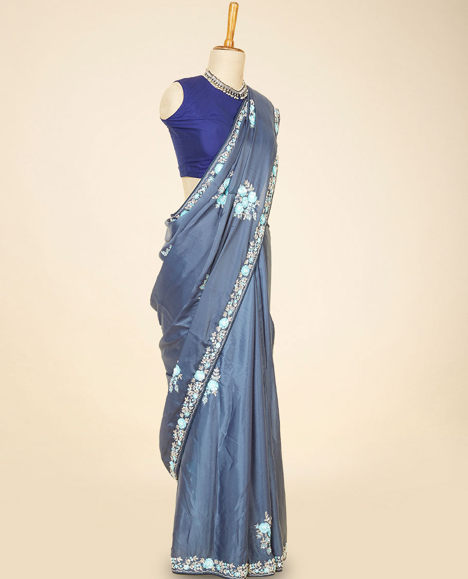 Grey embroidery satin silk saree bedecked with blue colour floral designs all over its body & pallu, embroidery border