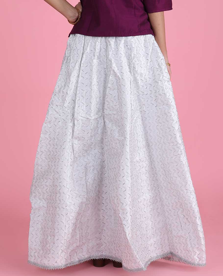 White silk cotton material skirt features chevron design sequin embroidery with lace border