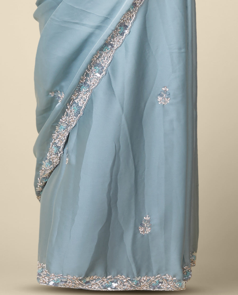 Pastel green embroidered satin silk saree features intricate designs in chamki, crystal stone & sliver thread