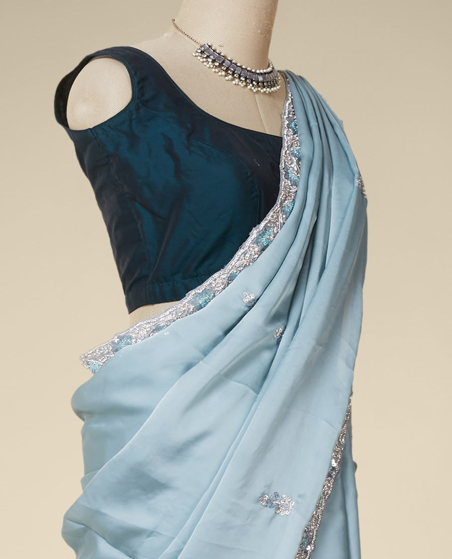 Pastel green embroidered satin silk saree features intricate designs in chamki, crystal stone & sliver thread
