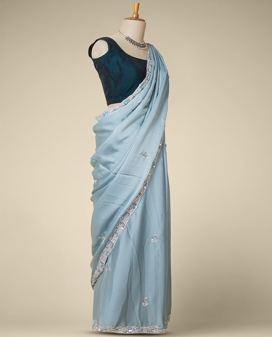 Pastel green embroidered satin silk saree features intricate designs in chamki, crystal stone & sliver thread