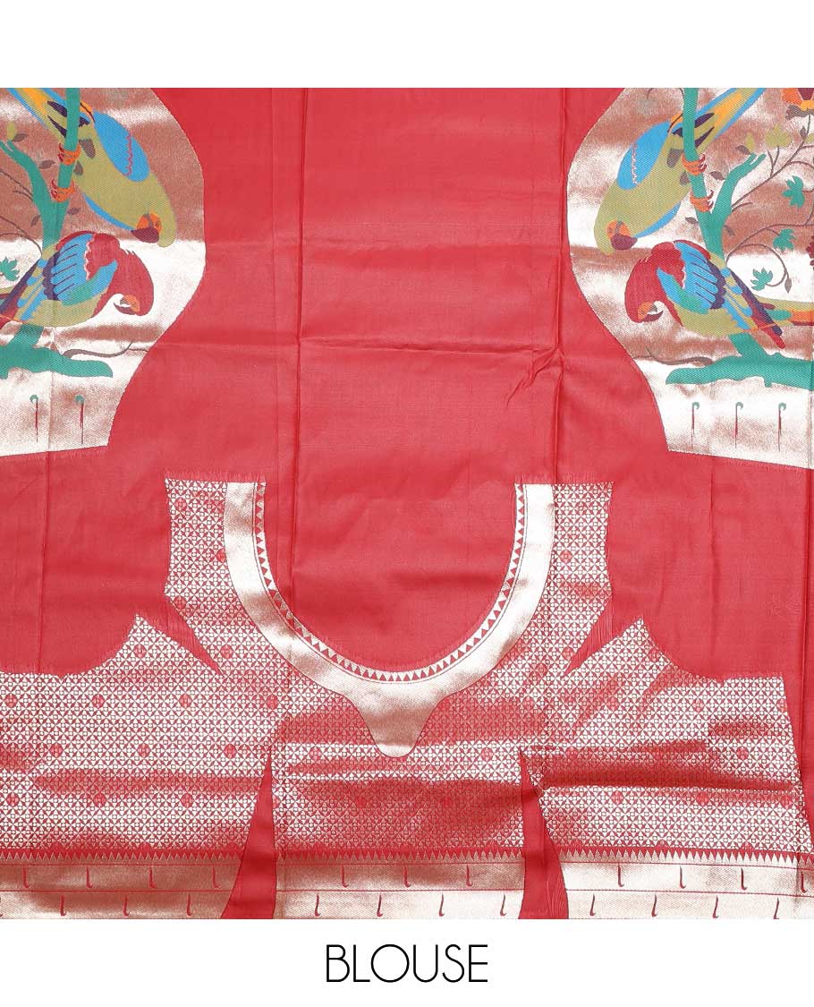 Red semi-paithani saree with buttas, contrast muniya border & pallu features multi-color floral vine & macaw parrots