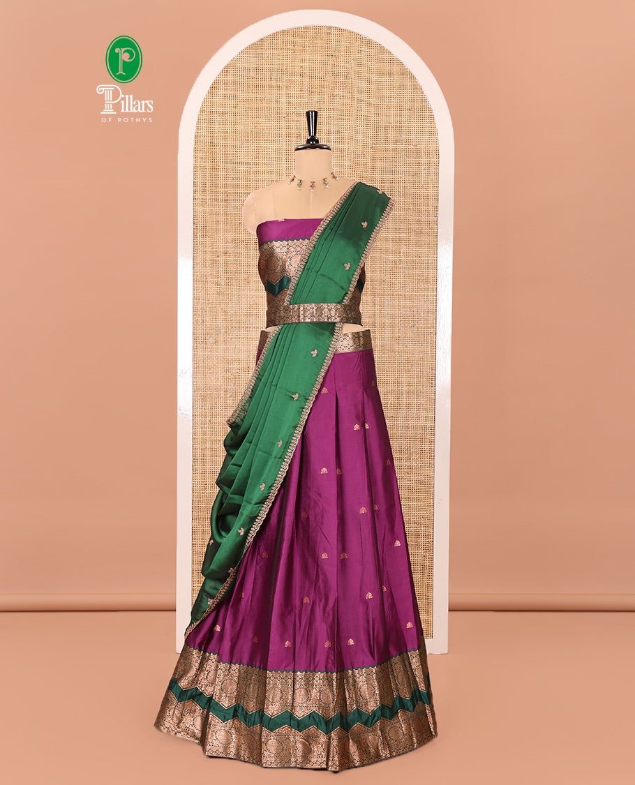 Purple and Green Semi-Banarasi Half-Saree Accentuated with Zari Buttas on Its Skirt, Complemented by Contrast Traditional Zari Border of Chakram Designs, Paired with a Matching Blouse, and a Satin Georgette Embroidered Scallop Dhavani