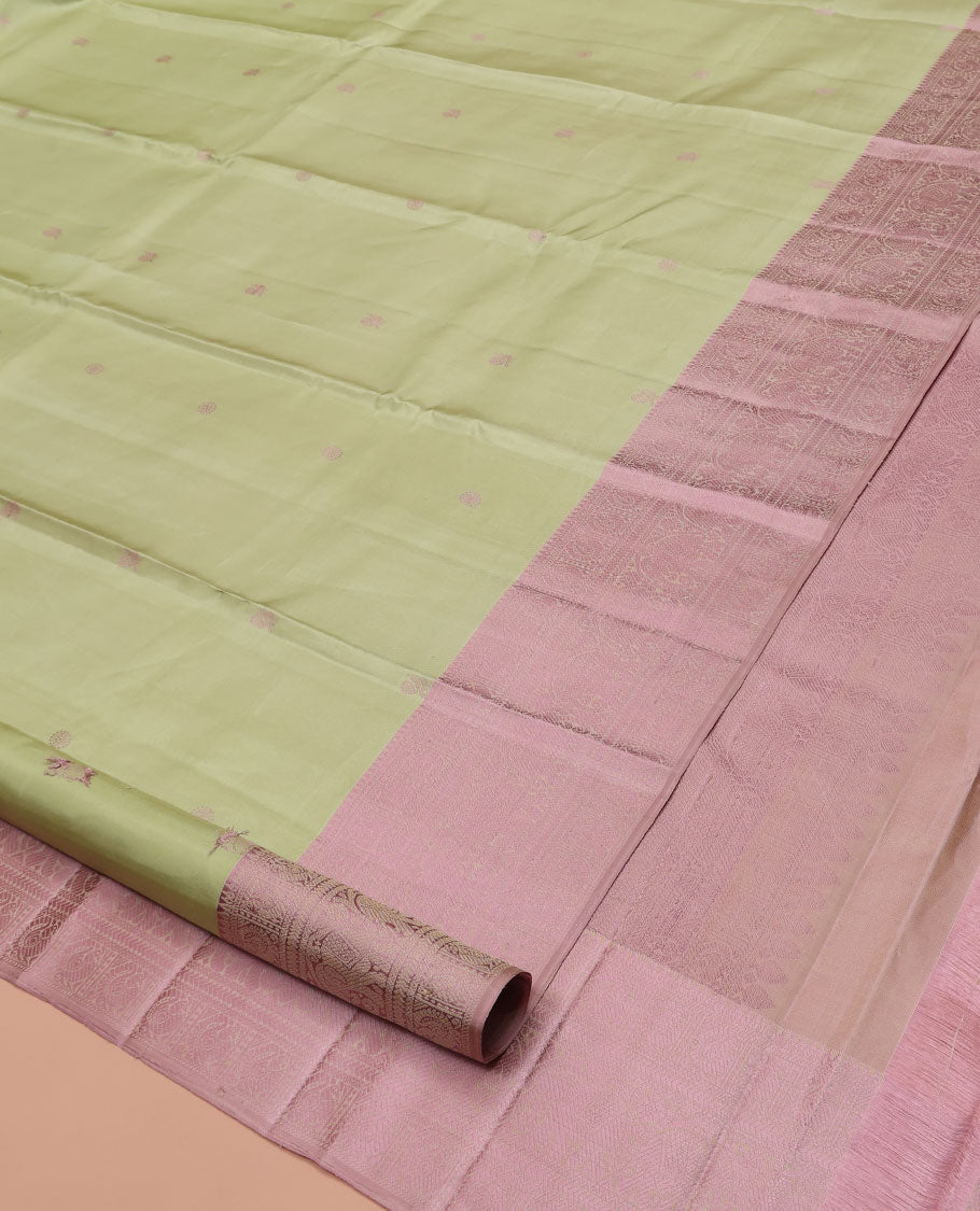 Pale Green Kanchipuram Designer Silk Saree, Subtly Sparkled With Buttas All Over Its Body Complemented by Contrast Traditional Designs Threaded Border, Subtly Woven Pallu, and Paired with a Contrast Blouse